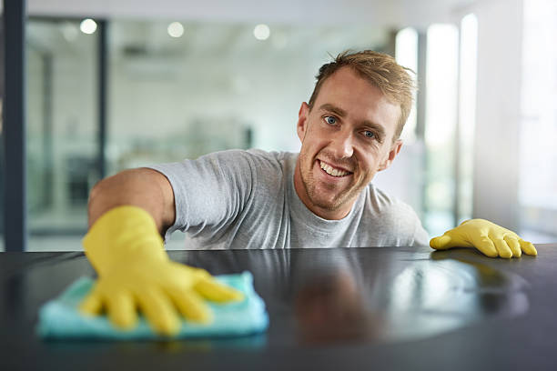 Pretty clean right? Portrait of a young man wiping off the surfaces in an office cleaner stock pictures, royalty-free photos & images