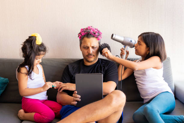 漂亮的女兒們正在畫指甲,梳理他們英俊的年輕父親的頭髮 - fathers day 個照片及圖片檔