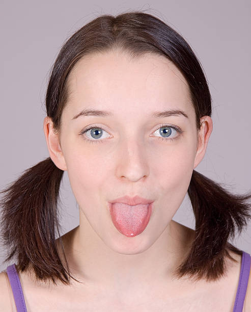pretty girl sticks out tongue stock photo