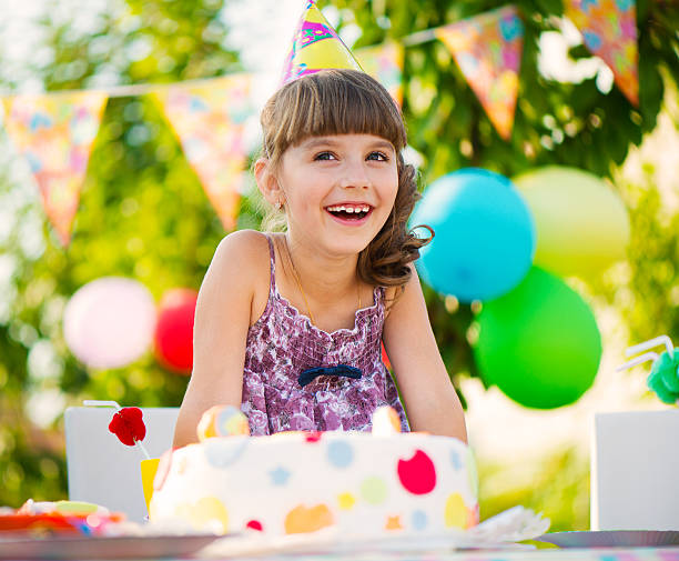 Pretty girl with cake at birthday party stock photo