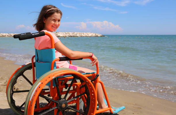 pretty little girl in the wheelchair by the sea pretty little girl in the wheelchair by the sea in the summer multiple sclerosis stock pictures, royalty-free photos & images