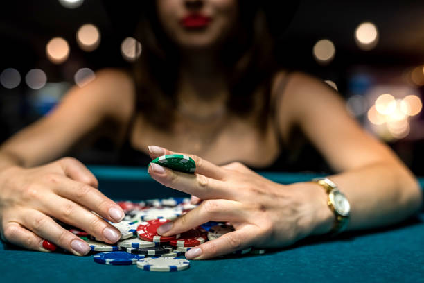 pretty woman in evening black dress plays poker in the casino stock photo
