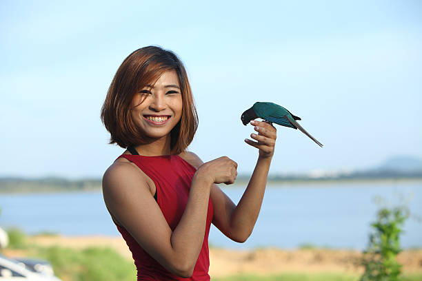 pretty woman pose and smile with green bird