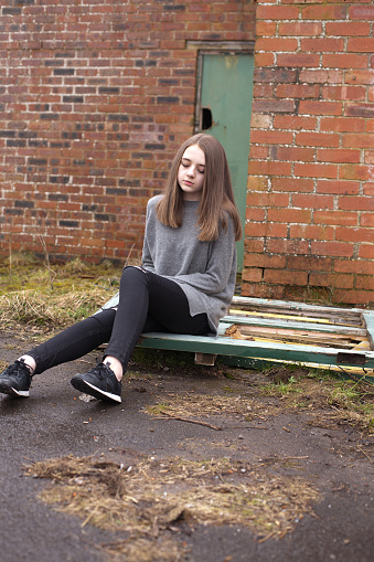 Pretty Young Teenage Girl Sitting Outside A Derelict 