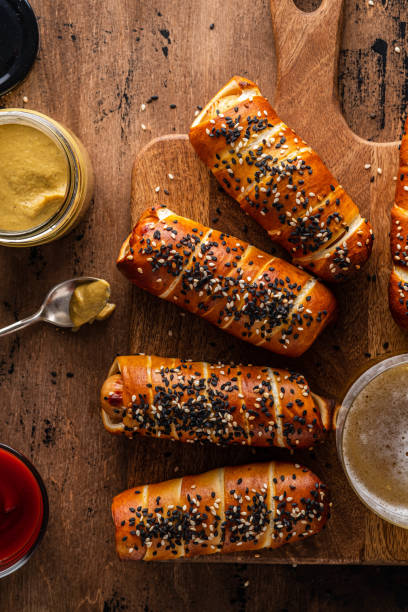 Pretzel dogs with sausages, with ketchup sauce, wooden background. Copy space. stock photo