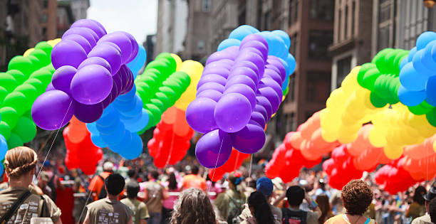 Pride Parade in New York City New York City, USA - June 26, 2011: Participants of New York City Gay Pride carrying rainbow colored balloons on the pride march. The New York City Gay Pride March is the oldest gay pride parade in the world, dating back to 1970. nyc pride parade stock pictures, royalty-free photos & images