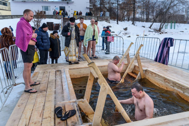 prästen viger ishålet. män badar i kallt vatten i ishålet. - ice bath in natural frozen lake bildbanksfoton och bilder