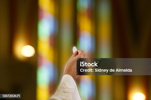istock Priest hand holding a host in Catholic celebration 1307203471