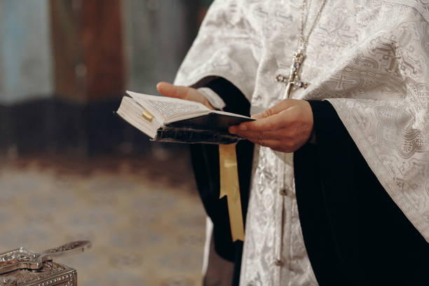 Priest reading holy bible in christian church during orthodox wedding ceremony, spiritual ritual concept Priest reading holy bible in christian church during orthodox wedding ceremony, spiritual ritual concept orthodox church stock pictures, royalty-free photos & images