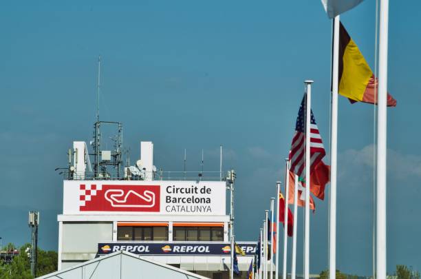 vista principale dell'edificio del circuito della catalogna, a montmeló (barcellona), con alcune bandiere del conte mondiale che sventolano - f1 barcellona foto e immagini stock