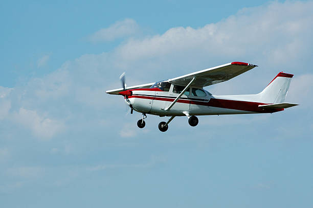 private airplane Cessna 172 in blue sky with white clouds stock photo