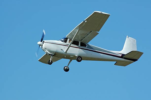 private airplane Cessna 182 flying in clear blue sky stock photo