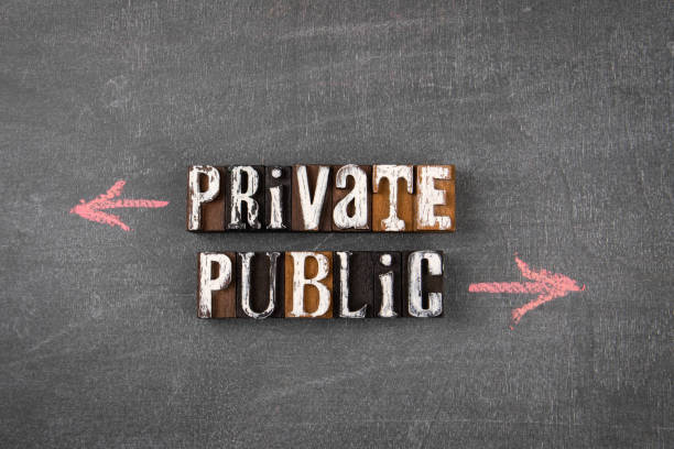 Private and Public. Directional arrows on a dark chalk board stock photo
