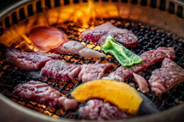 Process of cooking  barbecue raw beef on grill in restaurant stock photo