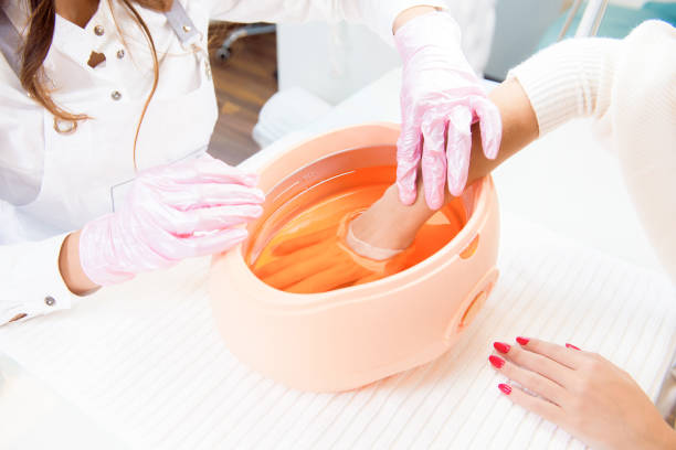 process paraffin treatment of female hands in beauty salon stock photo