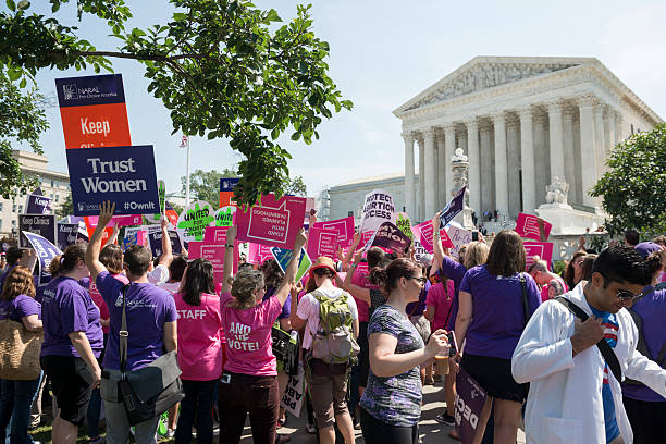 Pro-choice supporters at U.S. Supreme Court Washington DC, USA - June 27, 2016: Pro-choice supporters stand in front of the U.S. Supreme Court after the court, in a 5-3 ruling in the case Whole Woman's Health v. Hellerstedt, struck down a Texas abortion access law. abortion protest stock pictures, royalty-free photos & images