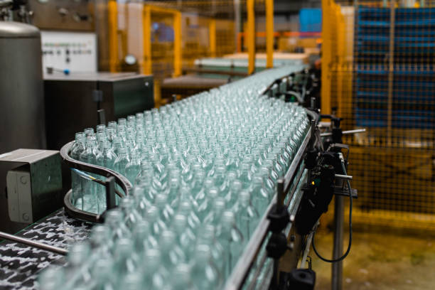 Production line for juice bottling Bottling factory - Apple juice bottling line for processing and bottling juice into bottles. Selective focus. plastic factory stock pictures, royalty-free photos & images