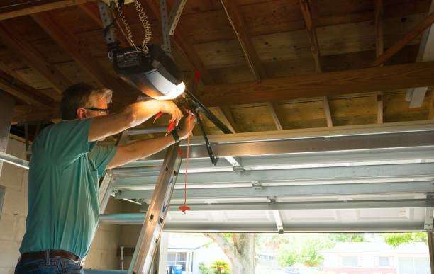 Professional automatic garage door opener repair service technician man working Professional automatic garage door opener repair service technician man working on a ladder at a home residential location making adjustments and fixing it while installing it. garage stock pictures, royalty-free photos & images