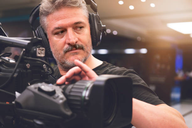 Professional cameraman with headphones with HD camcorder in live television stock photo