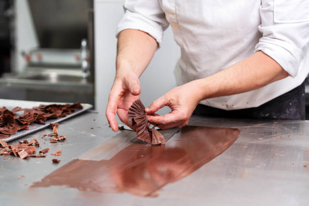 Professional confectioner making chocolate sweets at confectionery shop. Professional confectioner making chocolate sweets at confectionery shop . confectioner stock pictures, royalty-free photos & images