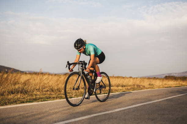 Professional female cyclist on the road stock photo
