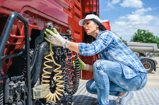 Professional female truck driver checks the correctness of the truck stock photo