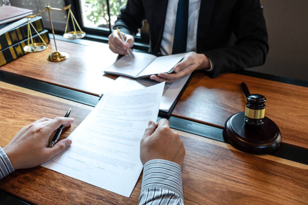 Professional male lawyer or counselor discussing negotiation legal case with client meeting with document contract in office, law and justice, attorney, lawsuit concept stock photo