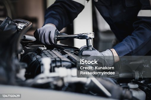 istock Professional mechanic working on the engine of the car in the garage. 1347150429