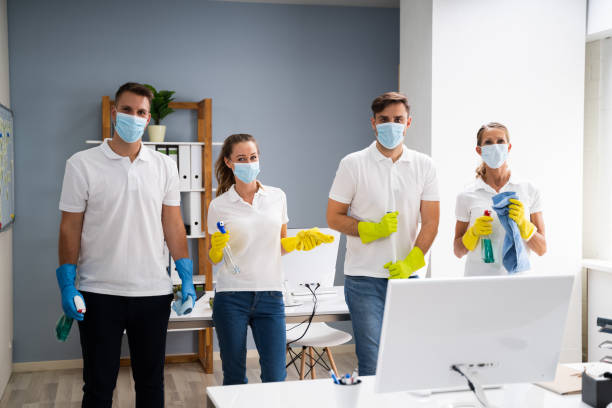 Professional Office Cleaning Janitor Team In Uniform Professional Office Cleaning Janitor Team In Uniform And Face Masks Office cleaning stock pictures, royalty-free photos & images