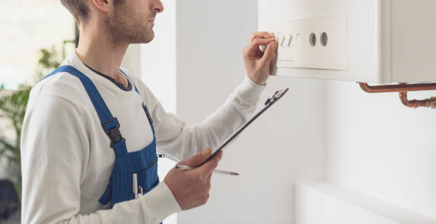 Professional plumber checking a boiler control panel stock photo