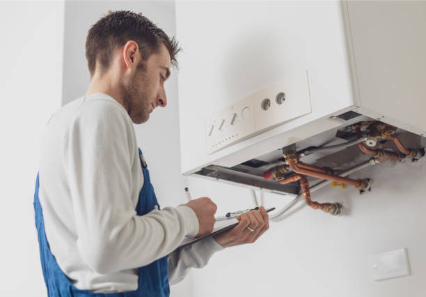 Professional plumber doing a boiler check stock photo