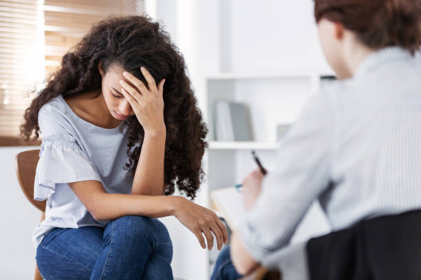 Professional psychotherapies and young woman suffering from ptsd Professional psychotherapies and young woman suffering from ptsd bad news stock pictures, royalty-free photos & images