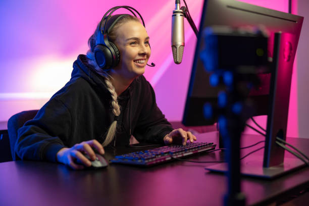Professional smiling esport gamer girl live streaming and plays online video game on PC stock photo