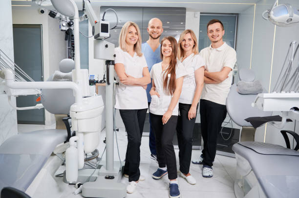 Professional team of dentists and assistants posing in their modern clinic stock photo