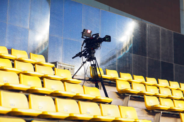 câmera profissional tv filmando o evento em um estádio - estádio e camera - fotografias e filmes do acervo