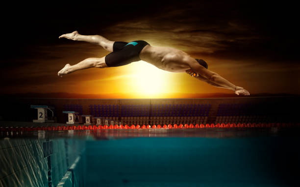 Professional young muscular swimmer in a swimming pool stock photo