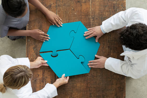 Professionals assembling 3 par puzzle piece, aerial view Three people each hold a puzzle piece and hold them out, putting them together. three people stock pictures, royalty-free photos & images