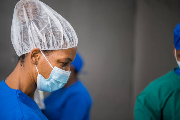 Profile nurse wearing hair net and face mask stock photo
