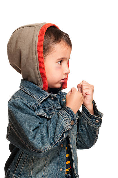 Profile portrait of little boy with shiner in fighting stance stock photo
