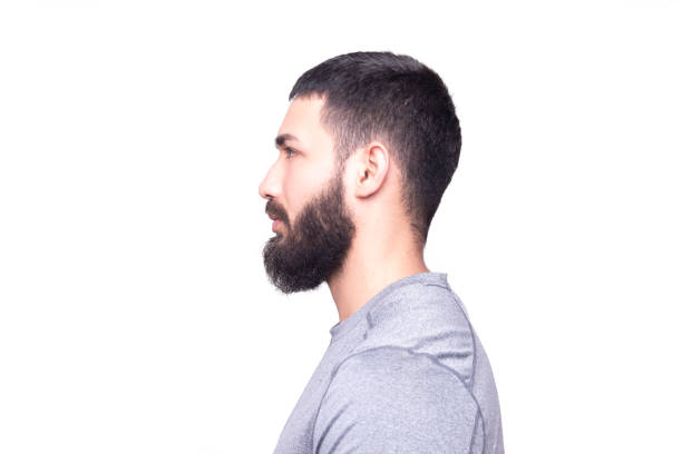 Profile view of a handsome young man looking away on a white background stock photo