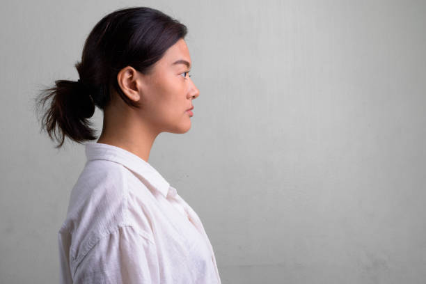profilansicht der jungen schönen asiatischen frau mit gebundenen haaren - profil stock-fotos und bilder