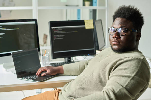 IT programmer working on laptop at office stock photo