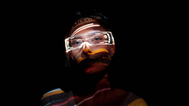Projection on a woman's face wearing futuristic glasses stock photo