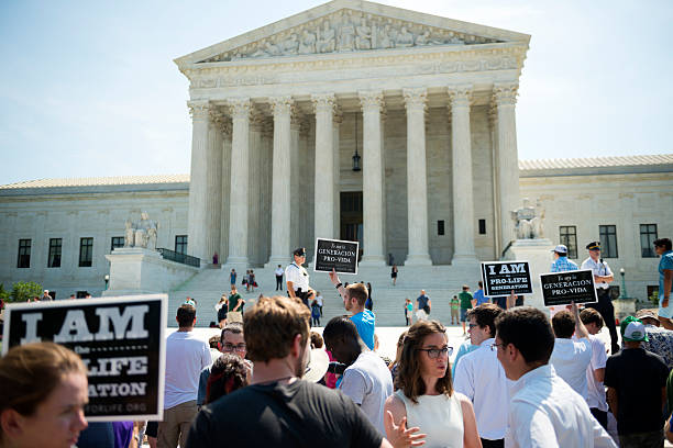 Pro-life supporters at U.S. Supreme Court Washington DC, USA - June 27, 2016: Pro-life supporters hold signs in front of the U.S. Supreme Court after the court, in a 5-3 ruling, struck down a Texas abortion access law that had been supported by pro-life groups. abortion protest stock pictures, royalty-free photos & images