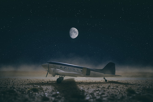 The Moon shines down on a model of the classic  propeller-driven airliner in the desert