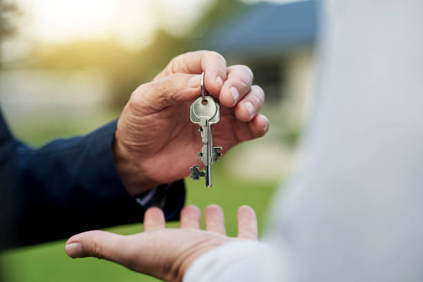 Property is a good investment Shot of an unrecognizable person handing over a key property management companies stock pictures, royalty-free photos & images