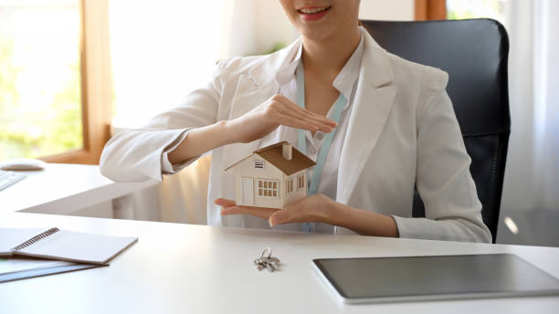 Property realtor or real estate agent holding a house model. stock photo