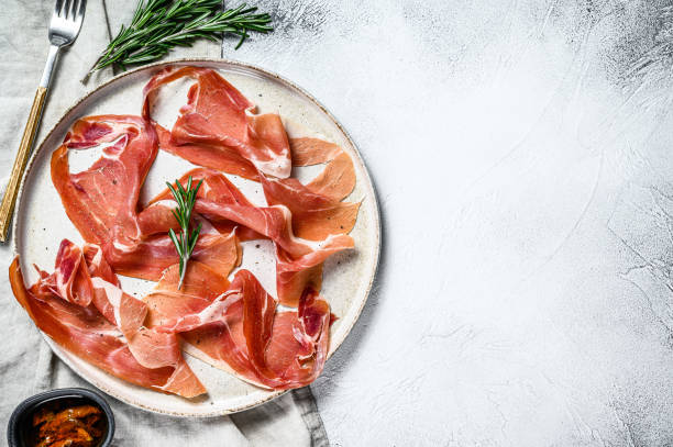 prosciutto crudo, italian salami, parma ham. Antipasto plate. Gray background, top view, space for text prosciutto crudo, italian salami, parma ham. Antipasto plate. Gray background, top view, space for text. prosciutto stock pictures, royalty-free photos & images