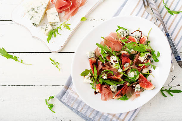 Prosciutto di Parma salad with figs and blue cheese. Flat lay. Top view Prosciutto di Parma salad with figs and blue cheese. Flat lay. Top view prosciutto stock pictures, royalty-free photos & images