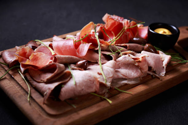 Prosciutto, ham and meat delicatessen on board gourmet snacks set, food photo art, luxury restaurant meals, meat plate. prosciutto, ham and finest delicious meat delicatessen on board delicatessen photos stock pictures, royalty-free photos & images